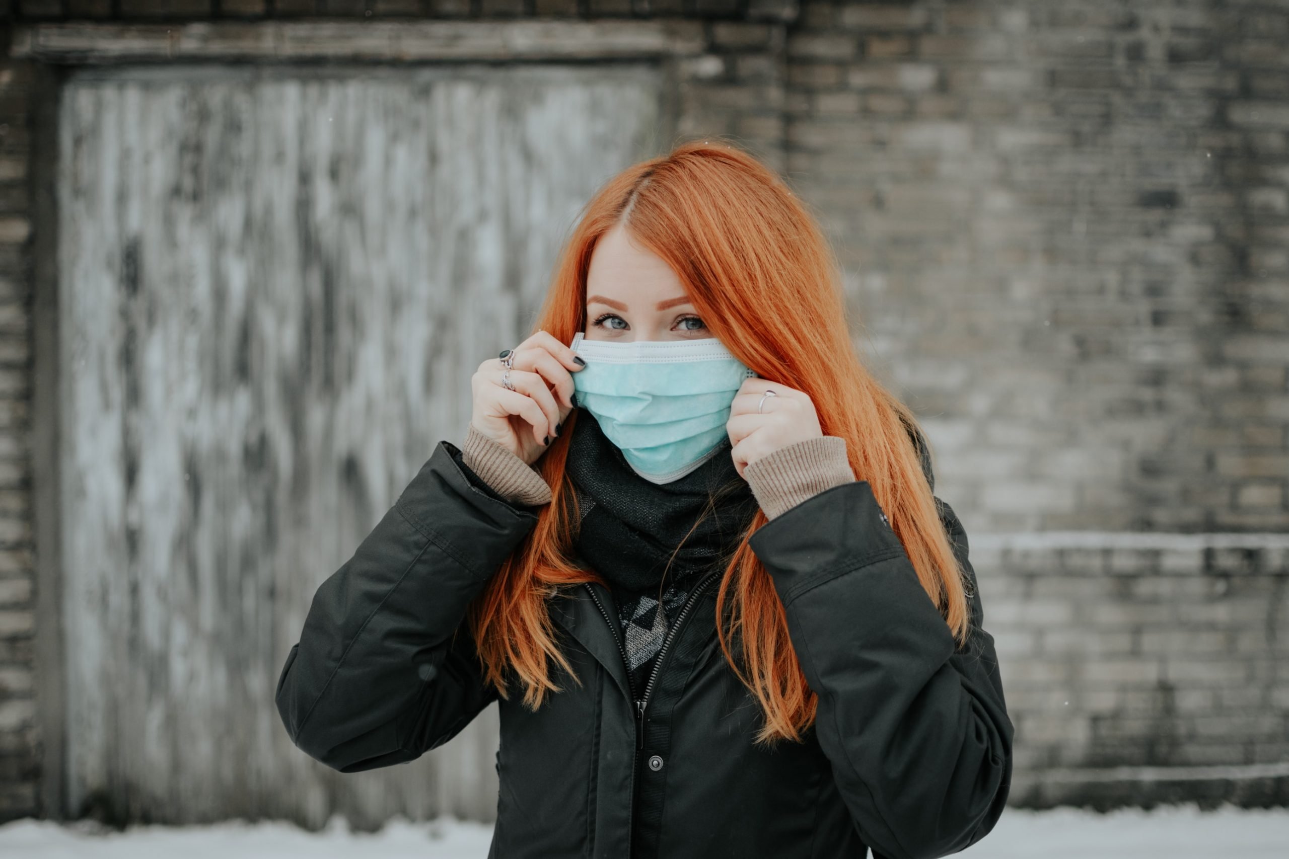 woman puts on face mask to fight Coronavirus crisis